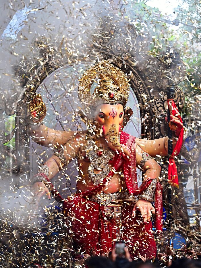Vivid photo of Lord Ganesha idol during vibrant Indian festival celebration bursting with color and life.
