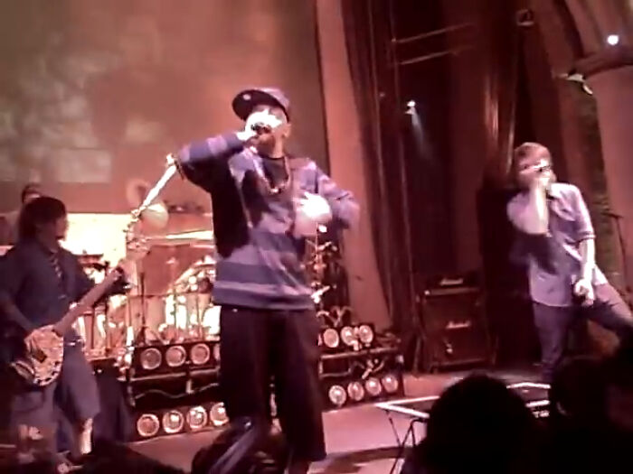 Live band performing on stage with singer and guitarist, captured in an intriguing video with unique context.