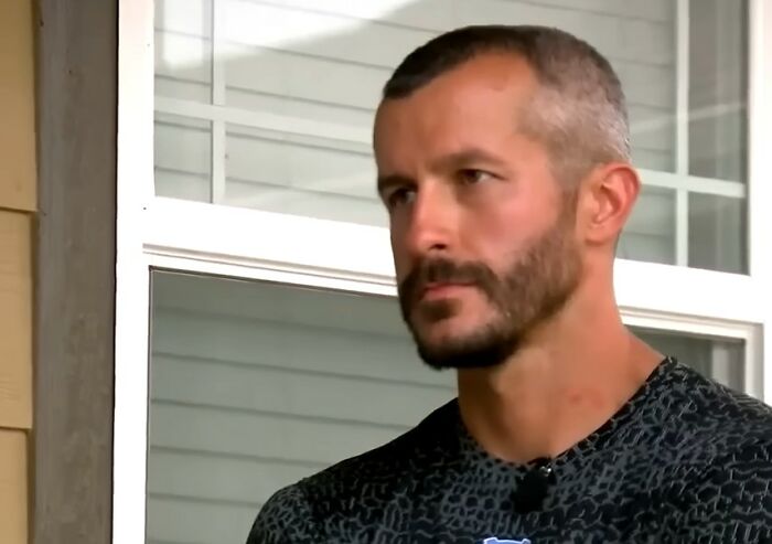 Man with short hair and beard sitting outdoors near a window, featured in videos that gain meaning with more context.
