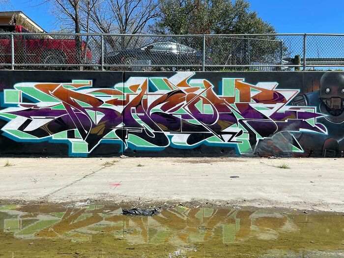 Colorful graffiti mural blending realism and abstraction with bold shapes and vibrant tones by Alexander Vizsla Bacon outdoors.