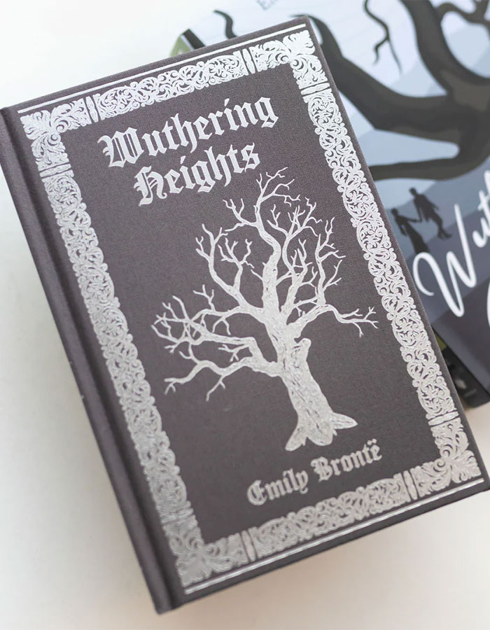 Hardcover edition of Wuthering Heights by Emily Brontë with ornate silver detailing and tree illustration on the cover. Hardcover edition of Wuthering Heights by Emily Brontë with ornate silver detailing and tree illustration on the cover.