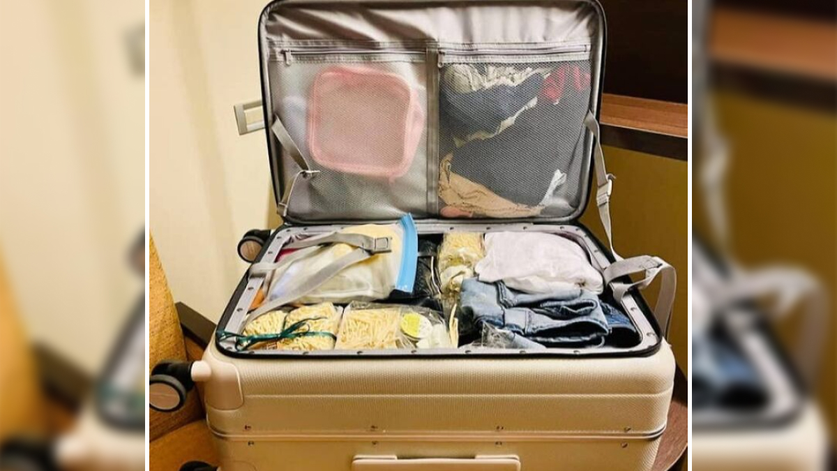 Open suitcase packed with organized clothes and travel accessories for people who are chronically bad at packing.