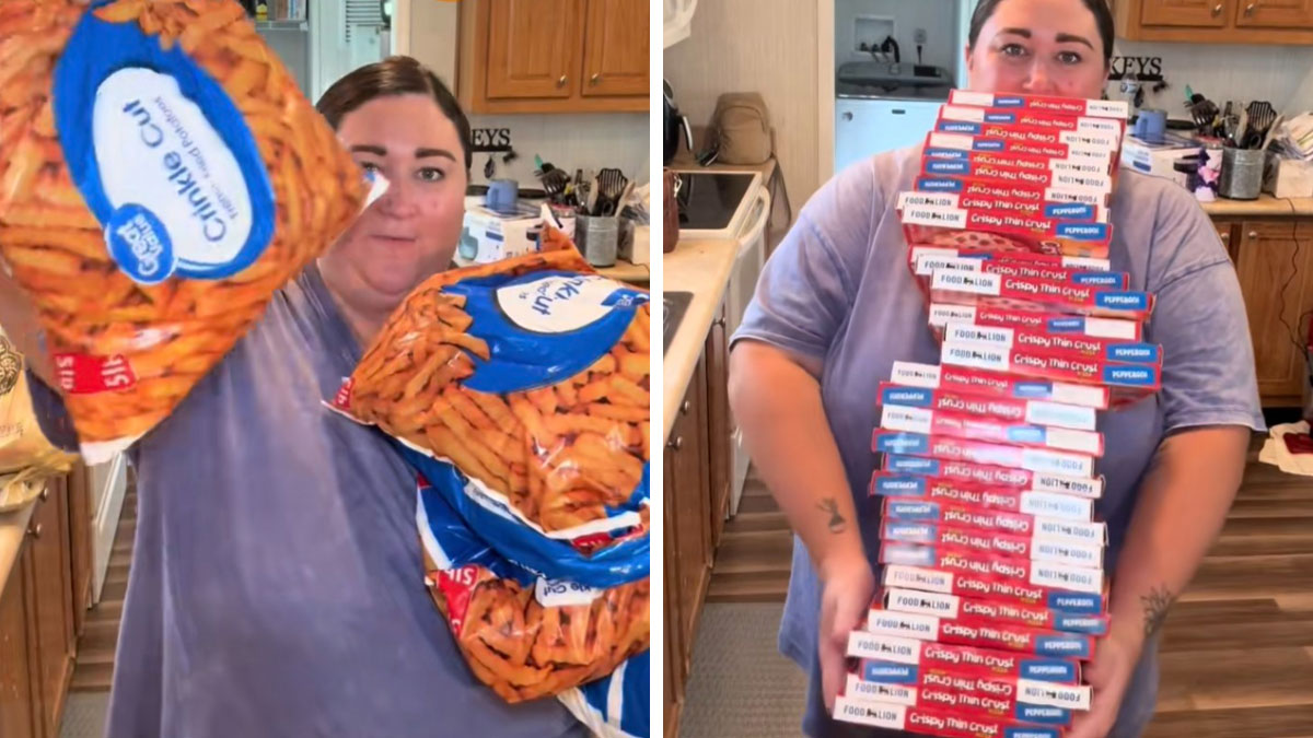 Woman holding multiple bags of American-style snacks and a large stack of frozen pizzas in a grocery haul at home.
