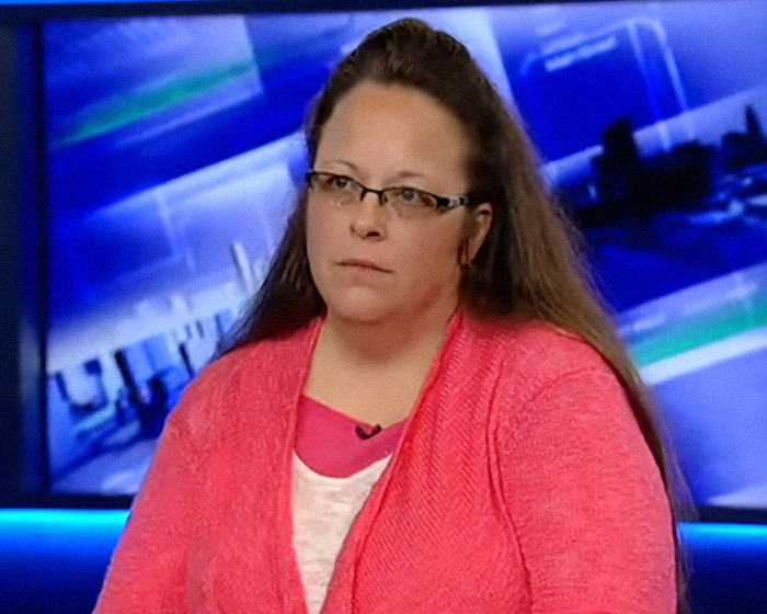 Kim Davis in a news interview wearing glasses and a coral sweater, known as an anti-LGBTQ activist. Kim Davis in a news interview wearing glasses and a coral sweater, known as an anti-LGBTQ activist.