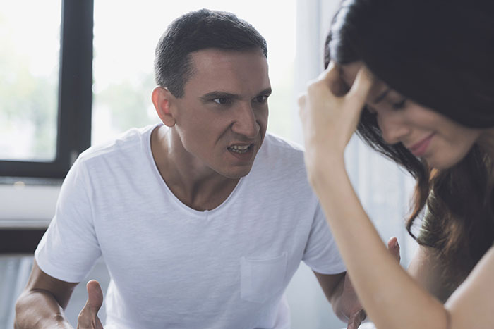 Angry partner scolding distressed heavily pregnant woman who appears upset and overwhelmed indoors. Angry partner scolding distressed heavily pregnant woman who appears upset and overwhelmed indoors.