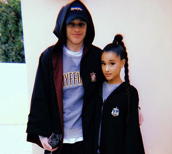 Pete Davidson wearing a Gryffindor robe standing next to a woman in Slytherin robe, both posing for a photo. Pete Davidson wearing a Gryffindor robe standing next to a woman in Slytherin robe, both posing for a photo.