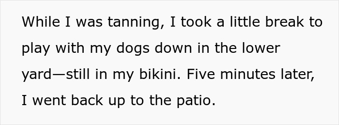 Woman wearing bikini in her own yard playing with dogs during a tanning break near the patio area. Woman wearing bikini in her own yard playing with dogs during a tanning break near the patio area.
