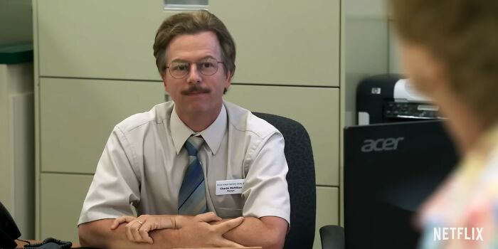 Man in office attire and glasses sitting at desk, representing Netflix movies that turned out to be total letdowns.