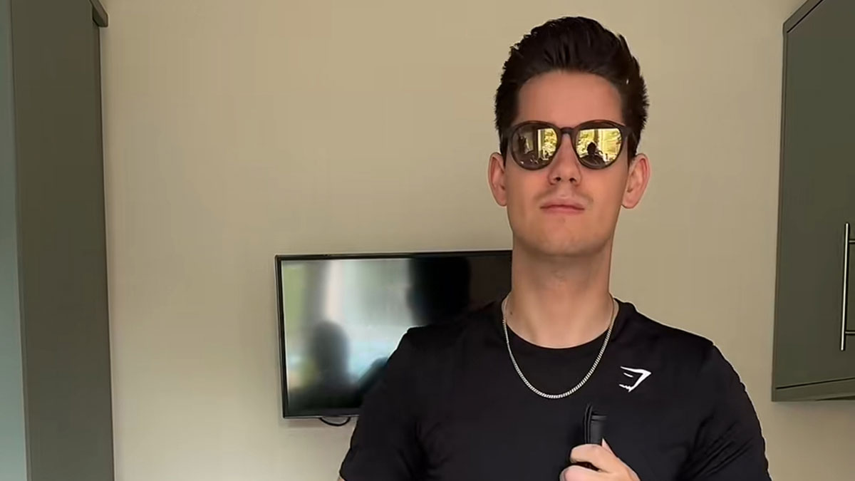 Young man wearing sunglasses indoors holding a white cane, representing experiences of an actual blind person.