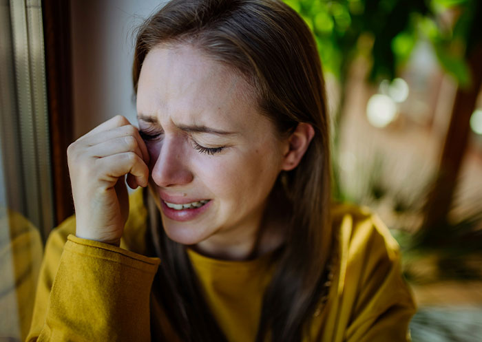 Woman faces heartbreak, crying by window, revealing true character of boyfriend after mother’s death.