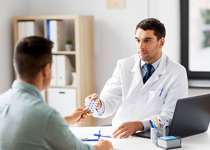 Doctor handing a patient medication in a clinical office, relating to cancer and HPV health concerns discussion. Doctor handing a patient medication in a clinical office, relating to cancer and HPV health concerns discussion.