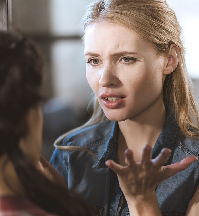 Woman confronting someone with an upset expression about copying her wedding dress in an intense conversation. Woman confronting someone with an upset expression about copying her wedding dress in an intense conversation.