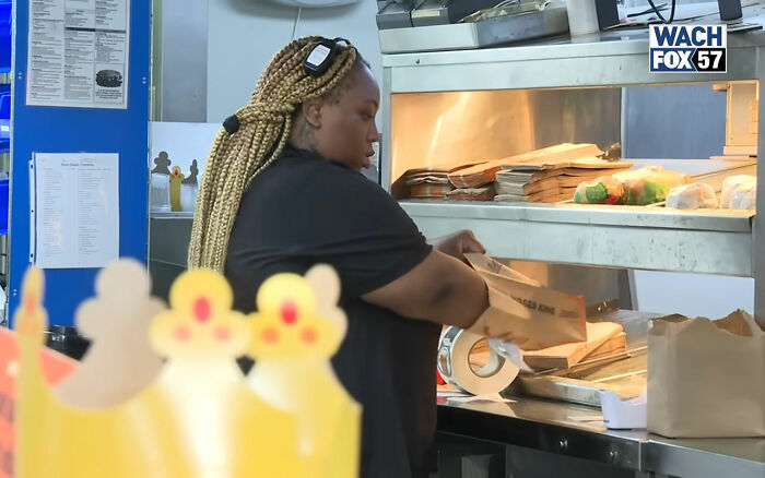 Burger King employee packing food bags inside restaurant kitchen during a work shift update. Burger King employee packing food bags inside restaurant kitchen during a work shift update.