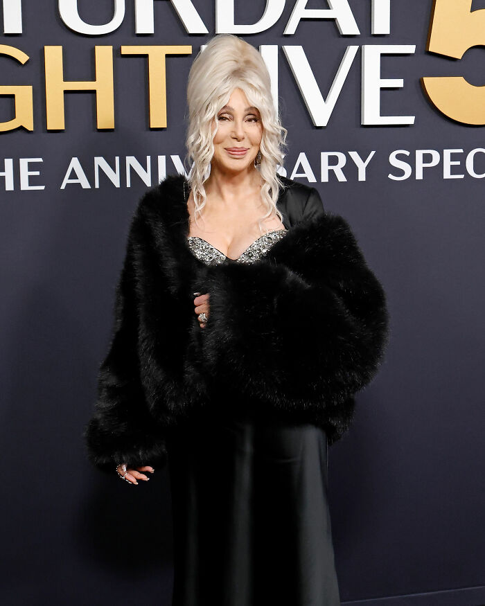 Cher at an event wearing a black fur coat and glittering top, sparking concern over her plastic surgery indulgence. Cher at an event wearing a black fur coat and glittering top, sparking concern over her plastic surgery indulgence.