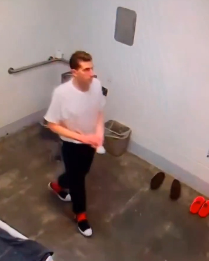 Bryan Kohberger with red hands inside jail cell wearing white shirt and black pants walking on concrete floor. Bryan Kohberger with red hands inside jail cell wearing white shirt and black pants walking on concrete floor.