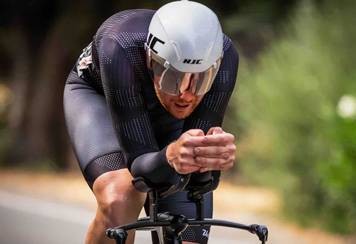 Cyclist in aerodynamic gear and helmet racing on road, symbolizing a good Samaritan protecting helpless family. Cyclist in aerodynamic gear and helmet racing on road, symbolizing a good Samaritan protecting helpless family.