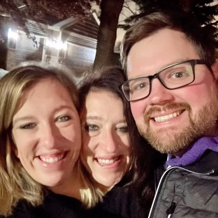 Three smiling adults outdoors at night, related to Hensel twins new baby and motherhood speculation. Three smiling adults outdoors at night, related to Hensel twins new baby and motherhood speculation.