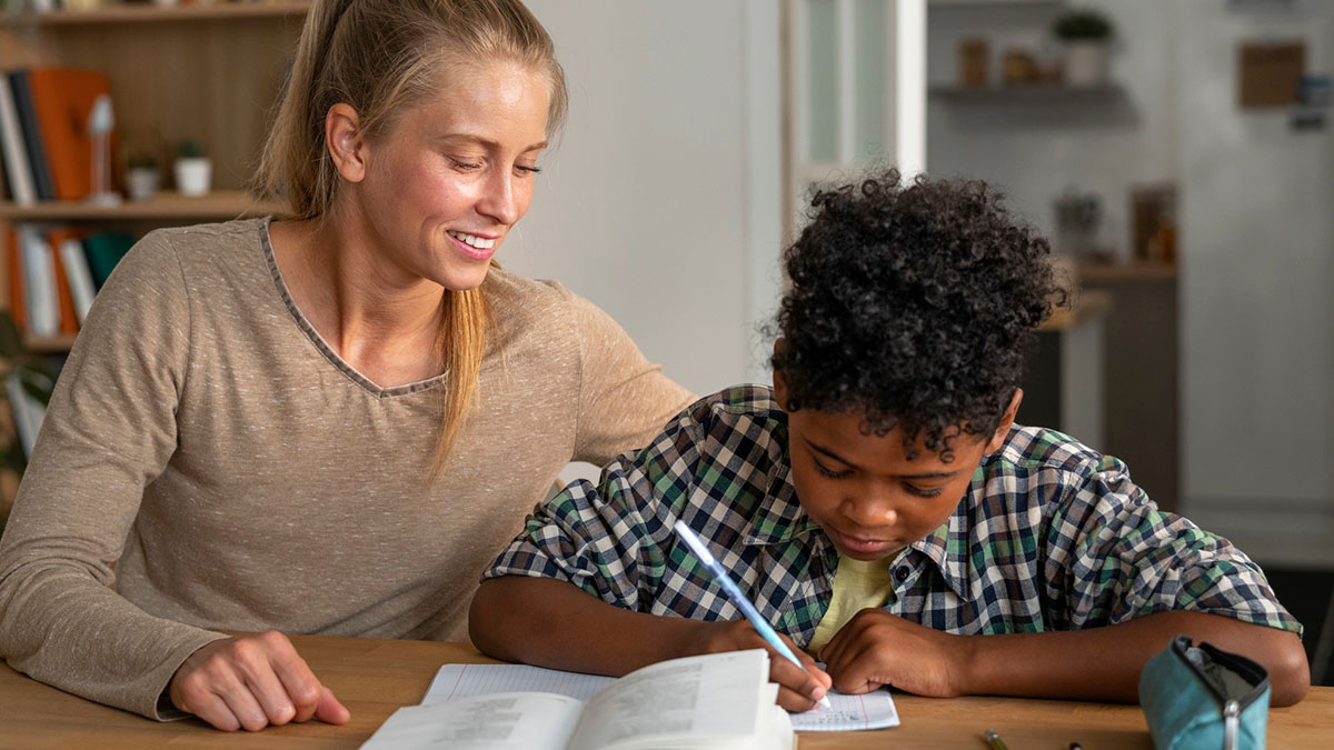 Teacher helping student with homework, representing unconscious bias training and concerns about racist thoughts.
