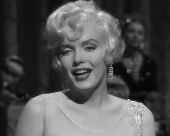 Black and white close-up of Marilyn Monroe smiling during a performance, related to autopsy suspicious finding revelations. Black and white close-up of Marilyn Monroe smiling during a performance, related to autopsy suspicious finding revelations.