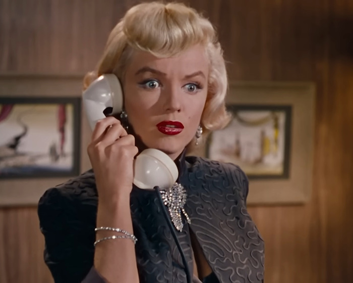 Woman resembling Marilyn Monroe holding a vintage phone with a shocked expression, linking to Marilyn Monroe autopsy findings. Woman resembling Marilyn Monroe holding a vintage phone with a shocked expression, linking to Marilyn Monroe autopsy findings.