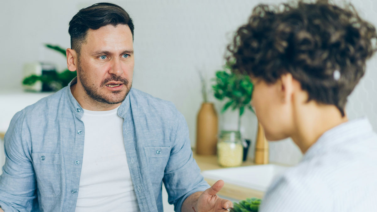 Couple having a serious conversation at home, discussing the ups and downs of a partner who went from rags to riches.