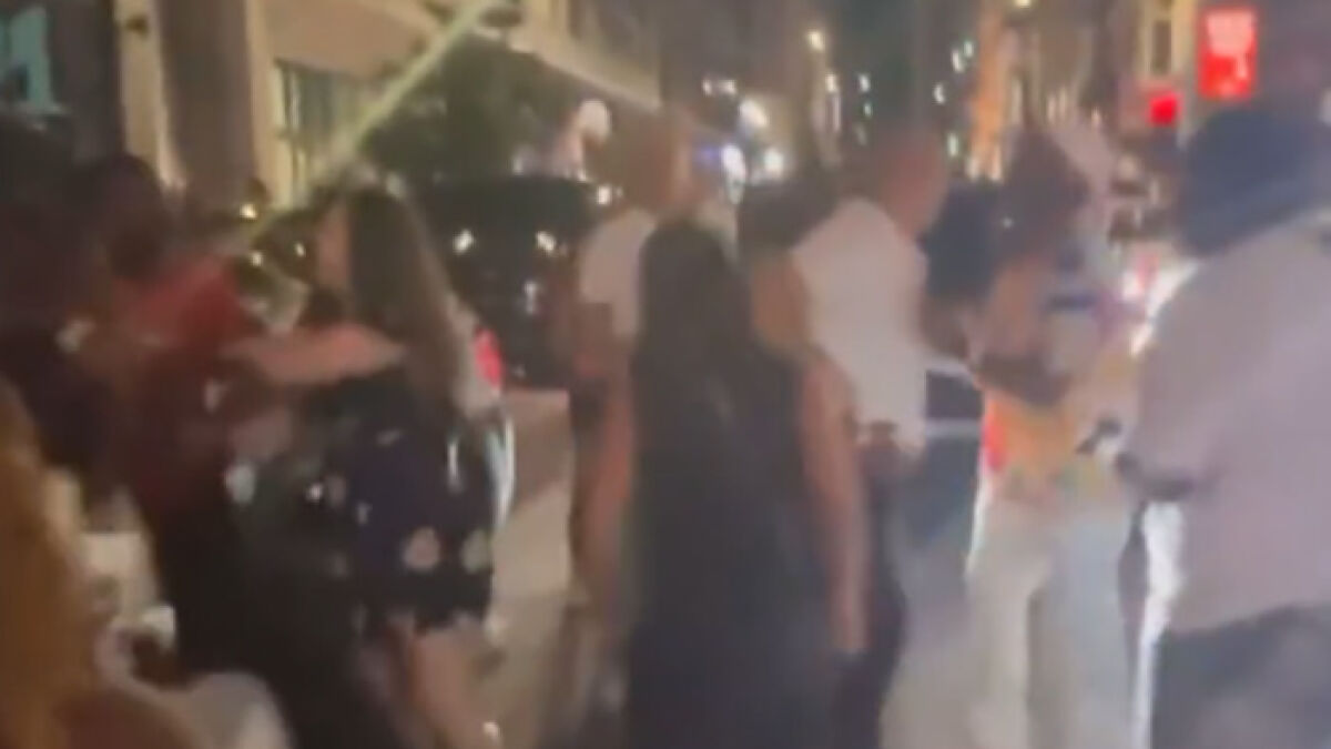 Crowd gathered on a street at night during a Cincinnati brawl as tensions rise over victimu2019s swollen face injuries.