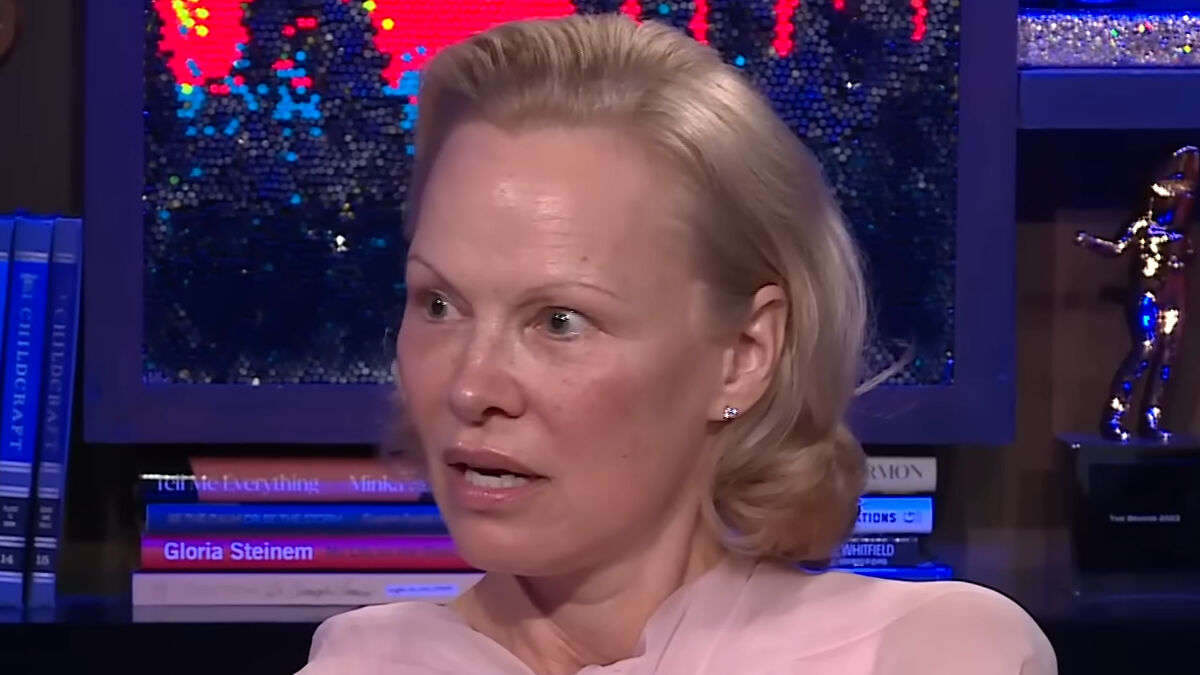 Pamela Anderson speaking during an interview, addressing fans' accusations about Meghan Markle's cooking show.