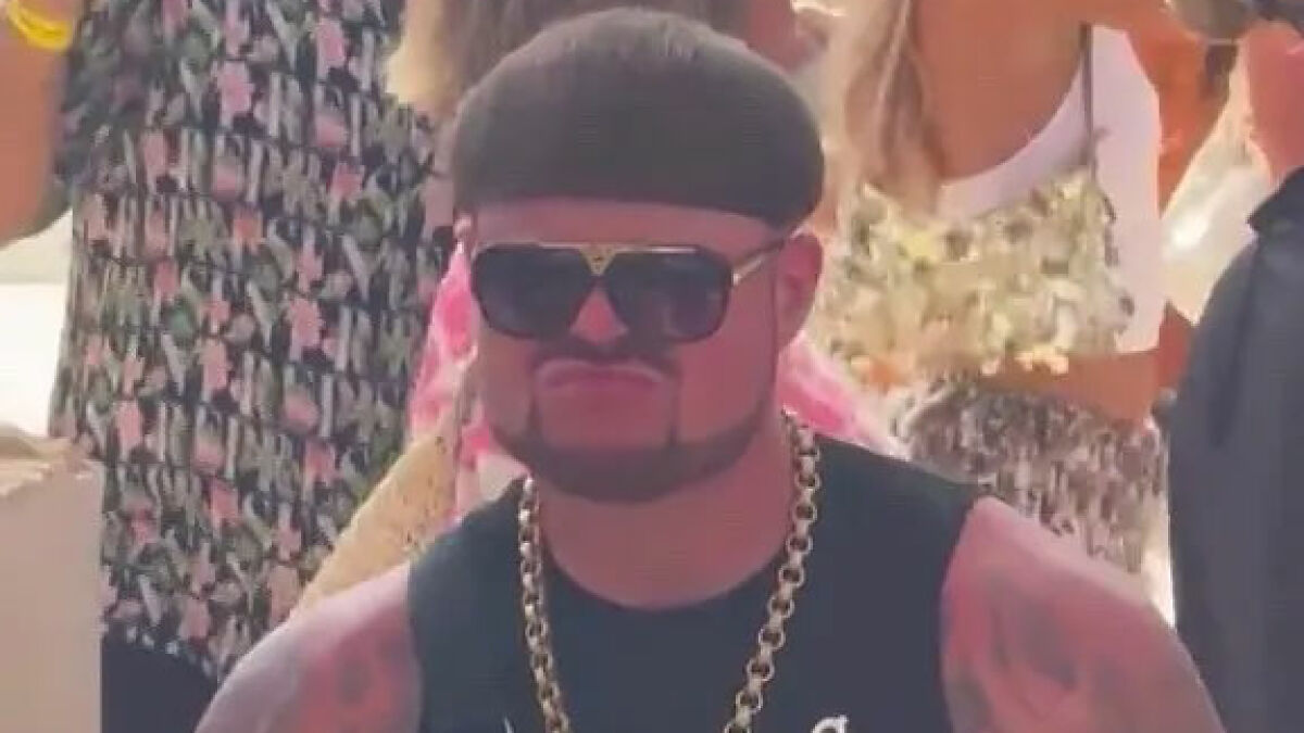Man with unique haircut and sunglasses at party, known as Ibiza Final Boss, drawing viral attention and meme frenzy.
