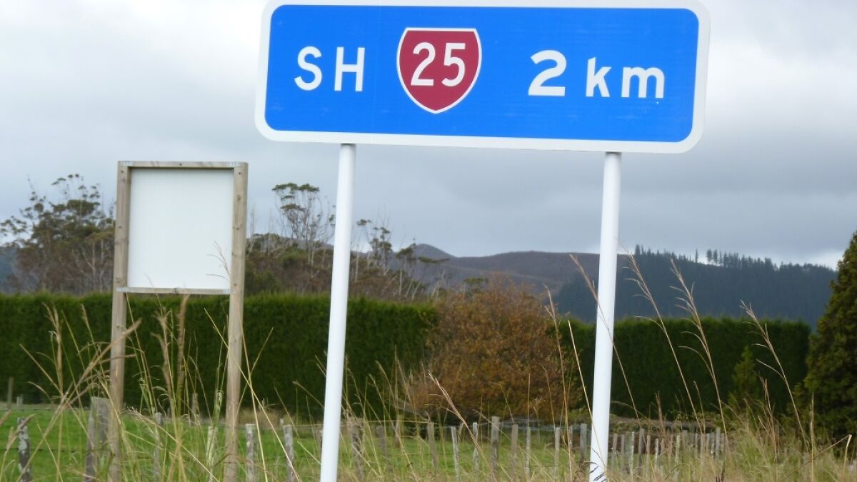 Blue road sign showing SH 25 and distance of 2 km, one of the collected signs around the world in a rural setting.