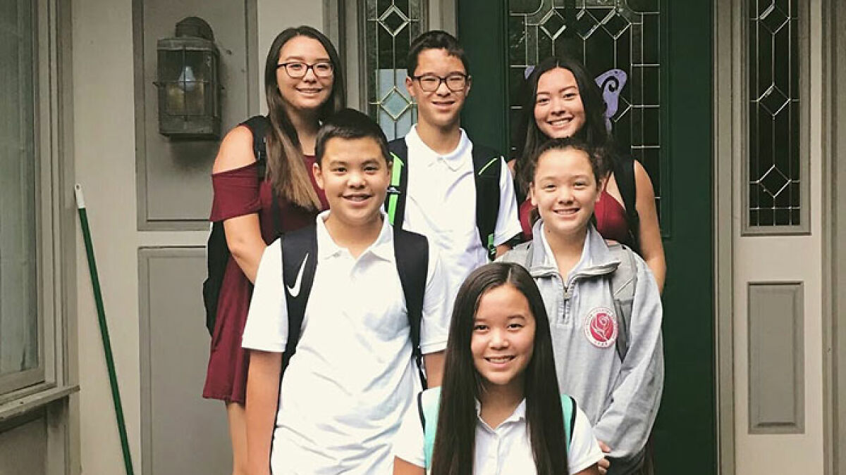 Group of smiling children standing outside a house, featuring Kate and Jon Gosselinu2019s son Collin in a casual setting.