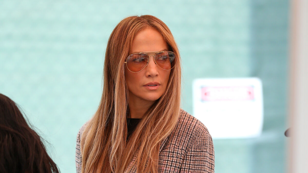 Jennifer Lopez wearing sunglasses and plaid jacket, related to Chanel entry denial and Bethenny Frankel store rejection controversy.