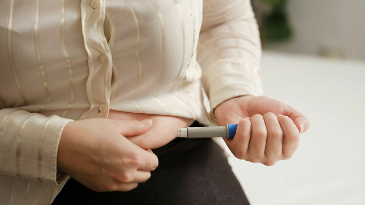 Person holding an injection pen near abdomen, illustrating scientists discovering Ozempic's healthier rival with no side effects.