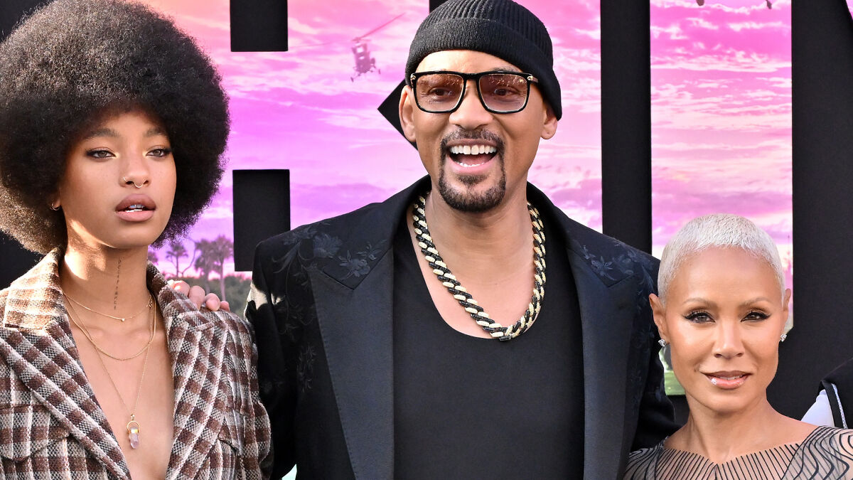 Will Smith and Jada Pinkett with their daughter at a red carpet event, showing family togetherness and style.