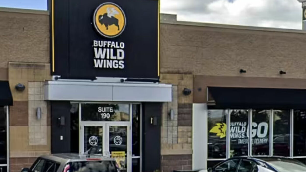 Buffalo Wild Wings restaurant exterior with parked cars, related to teen altercation with server over gender proof.