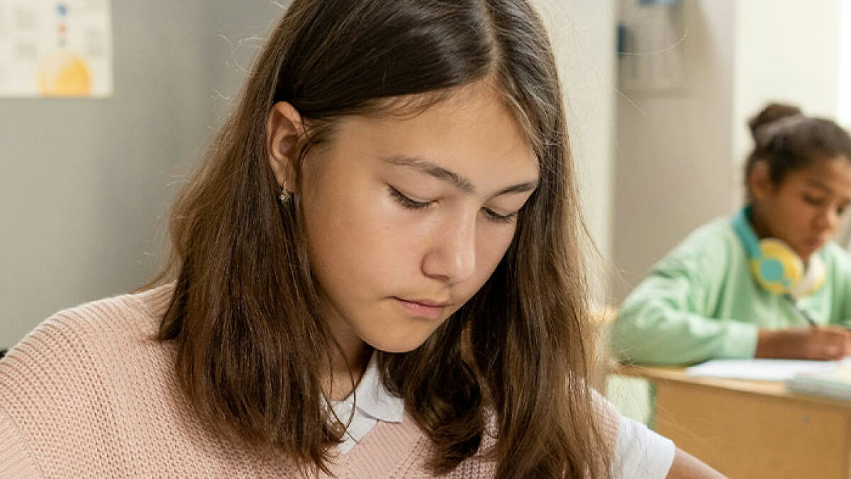 Student focused on schoolwork in a classroom setting, related to teacher's private parts song for first grade kids going viral