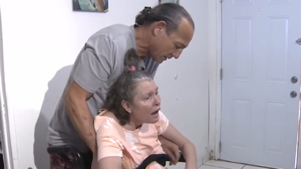 Woman in a wheelchair being assisted by a man indoors, discussing weight gain and a surprising medical diagnosis.