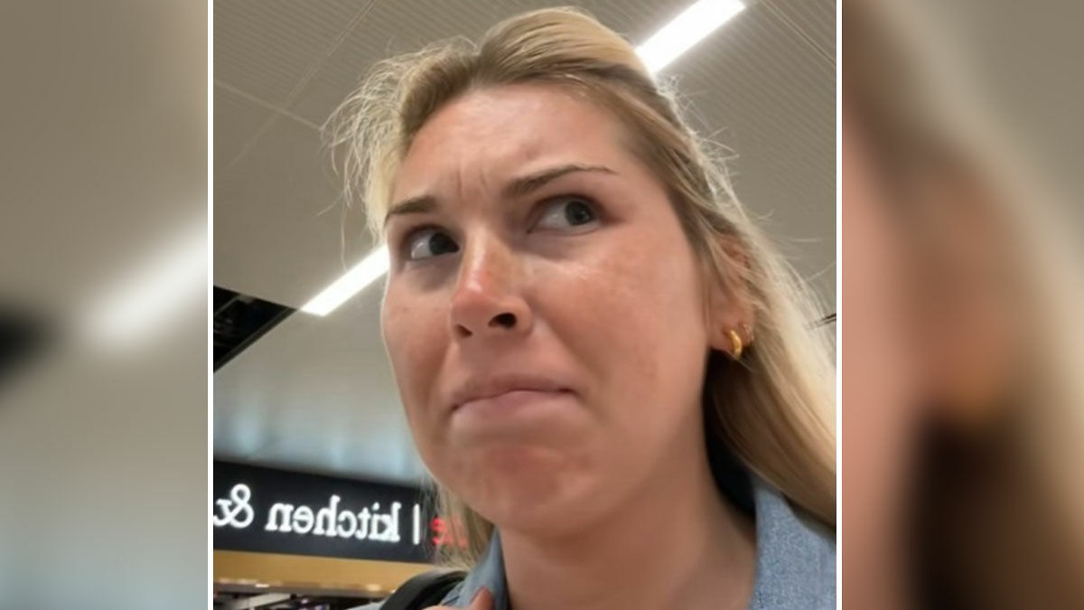 Close-up of a woman with a concerned expression during a heated debate with a passenger about bag watching at the airport.