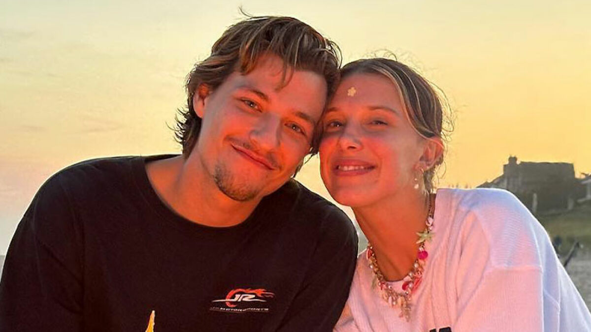Young couple smiling closely during sunset, related to Millie Bobby Brownu2019s baby adoption debate and career discussions.