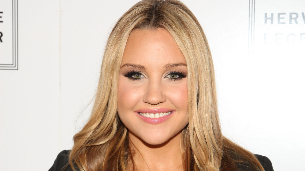 Blonde woman with heavy makeup posing at an event, example of celebrities affected by cosmetic procedures.