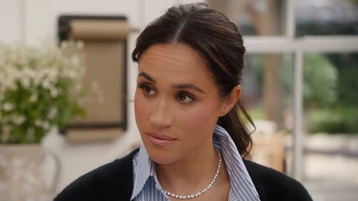 Meghan Markle expressing emotions during an interview about Queen Elizabethu2019s passing in a casual indoor setting