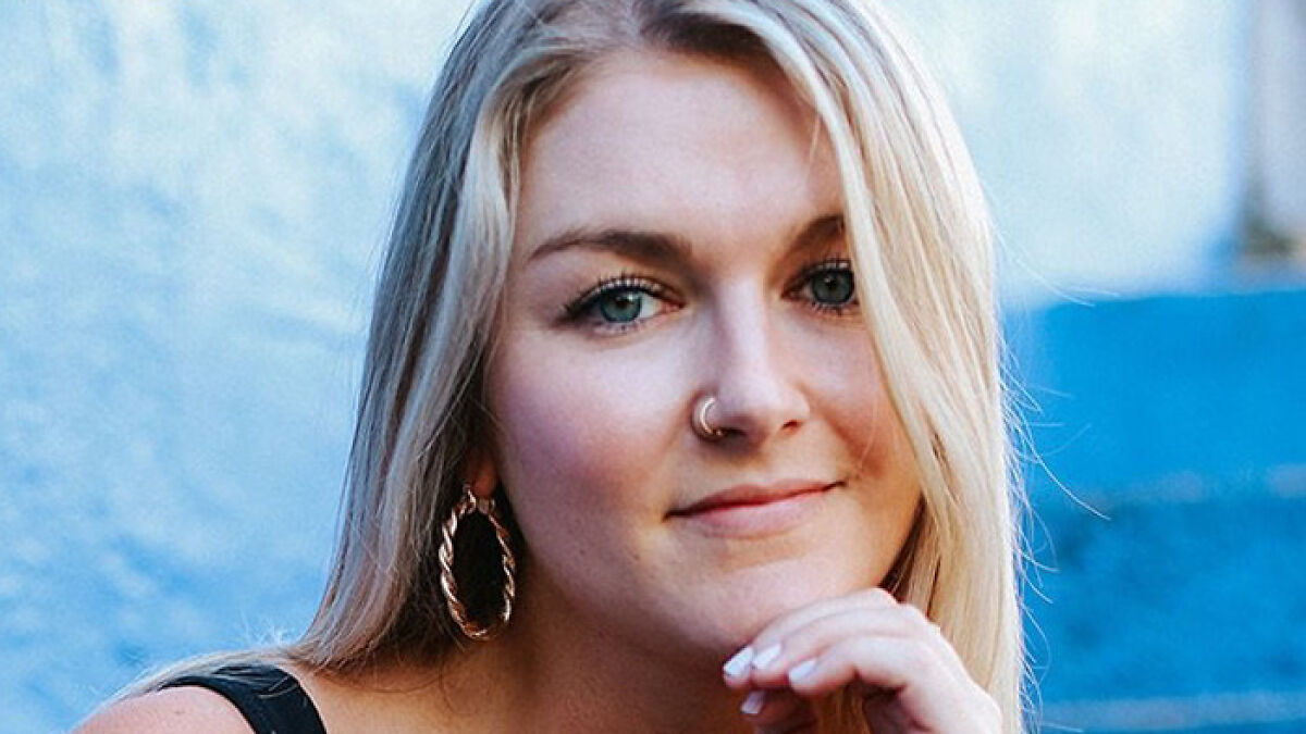 Woman with blonde hair and nose ring sharing her experience of smart ring detecting major illness early.