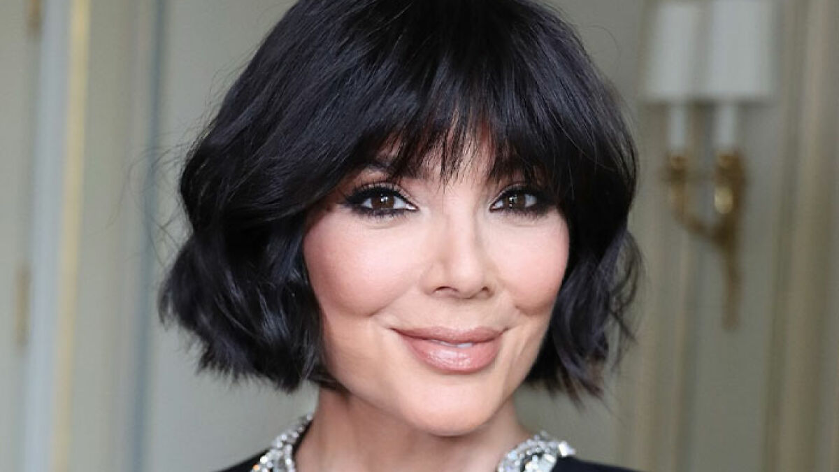 Kris Jenner smiling with short black hair and makeup, addressing viral facelift rumors and aging gracefully.