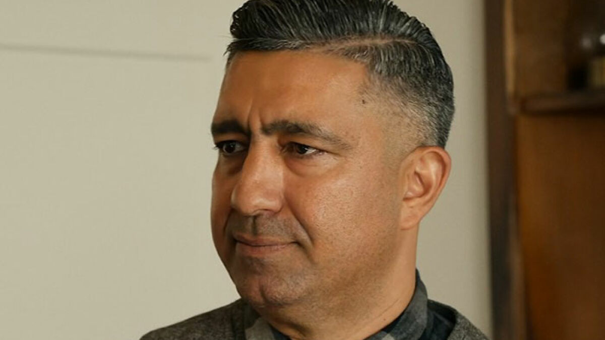 Man with short black hair and gray shirt looking serious during a Netflix guest exchange involving Meghan Markle shade