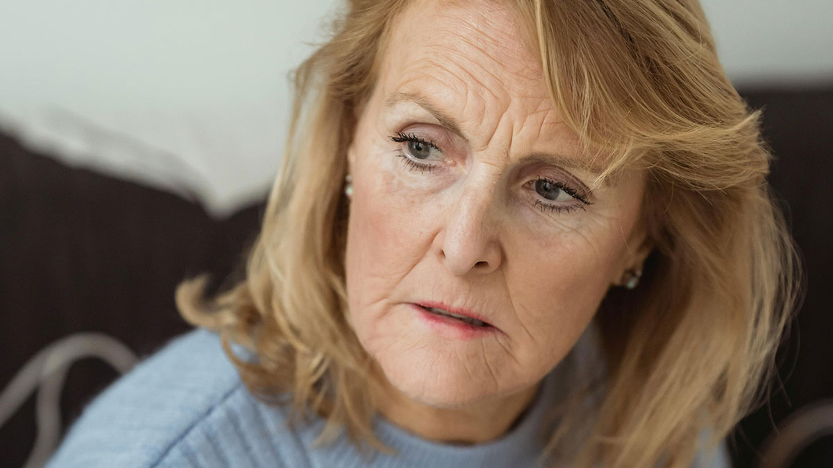 Worried woman with blonde hair and blue sweater, reflecting on fears about mother-in-law and pregnancy changes.