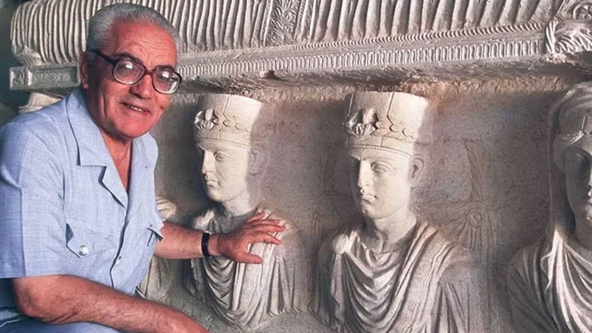Elderly man with glasses showing ancient carved stone reliefs featuring crowned figures, illustrating facts and stories.