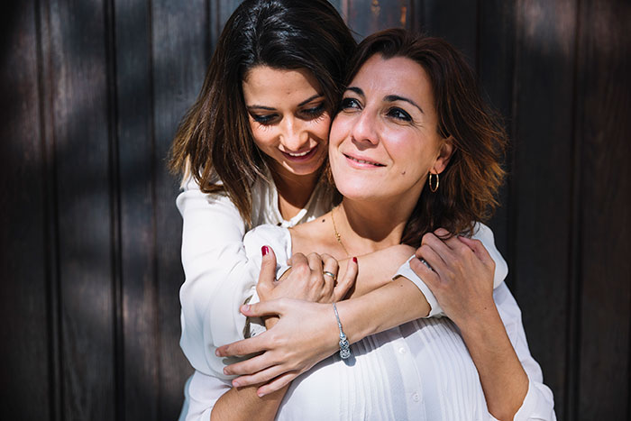 Mother and daughter embracing outdoors, reflecting on stepdad suggesting punishing kid for using native language. Mother and daughter embracing outdoors, reflecting on stepdad suggesting punishing kid for using native language.