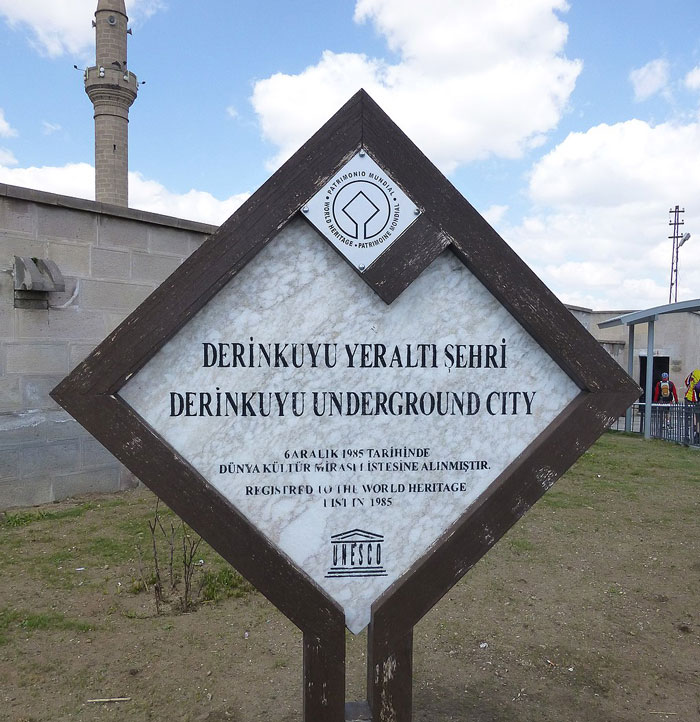 Sign at Derinkuyu Underground City entrance, highlighting the mysterious underground city's depth and historic significance. Sign at Derinkuyu Underground City entrance, highlighting the mysterious underground city's depth and historic significance.