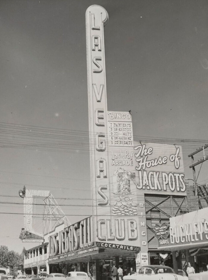 Historic black and white image of a Las Vegas casino sign and street scene from the birth of Vegas era.
