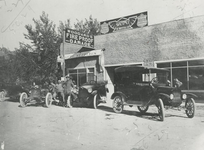 Historic black and white photo showing vintage cars and people outside Woodard's fireproof garage in early Vegas.