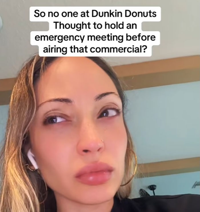 Woman wearing AirPods with confused expression questioning Dunkin Donuts ad amid woke genetics controversy. Woman wearing AirPods with confused expression questioning Dunkin Donuts ad amid woke genetics controversy.